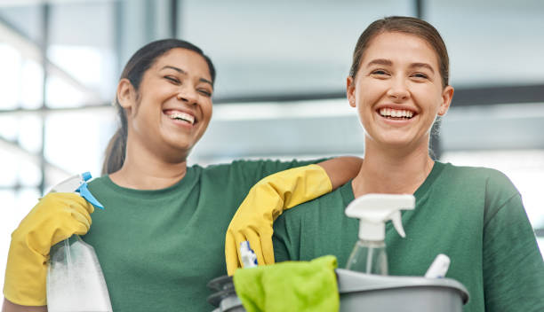 Portrait of two young woman cleaning a modern office